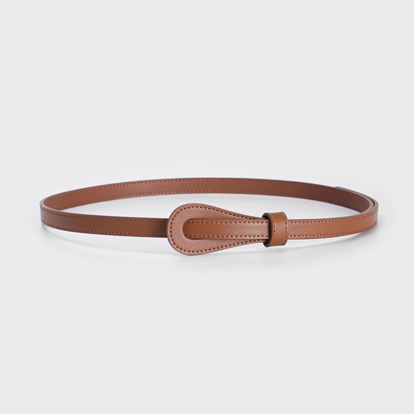 Brown leather belt with a decorative buckle on a light gray background