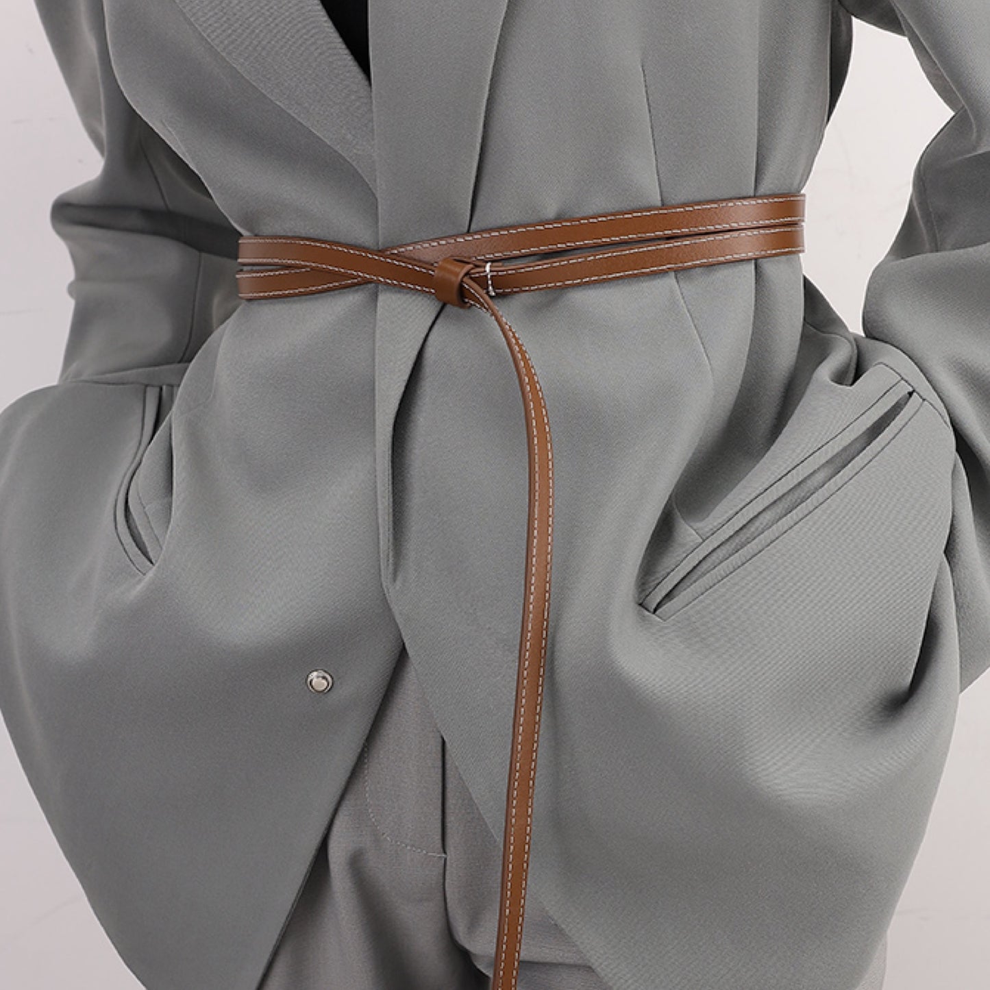 Gray coat with a brown belt on a plain background