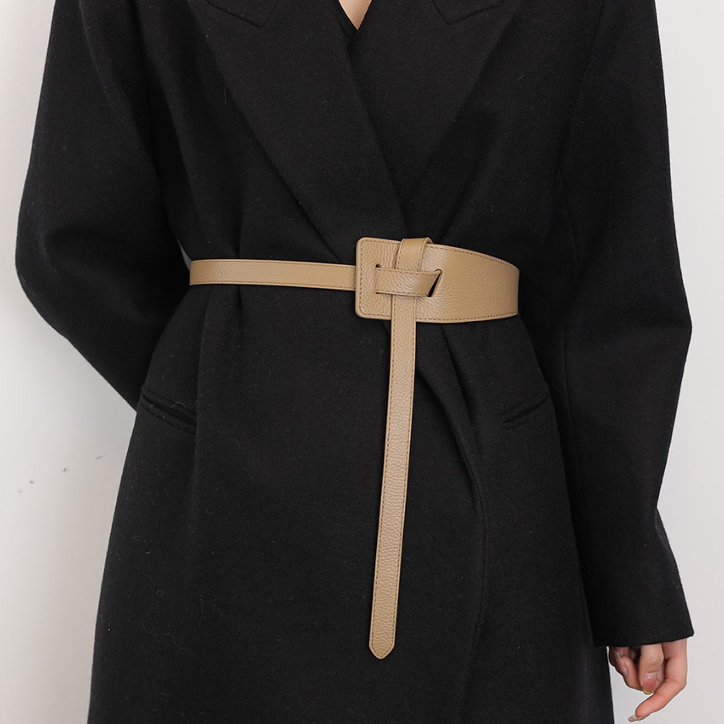 Black coat with a beige belt on a white background
