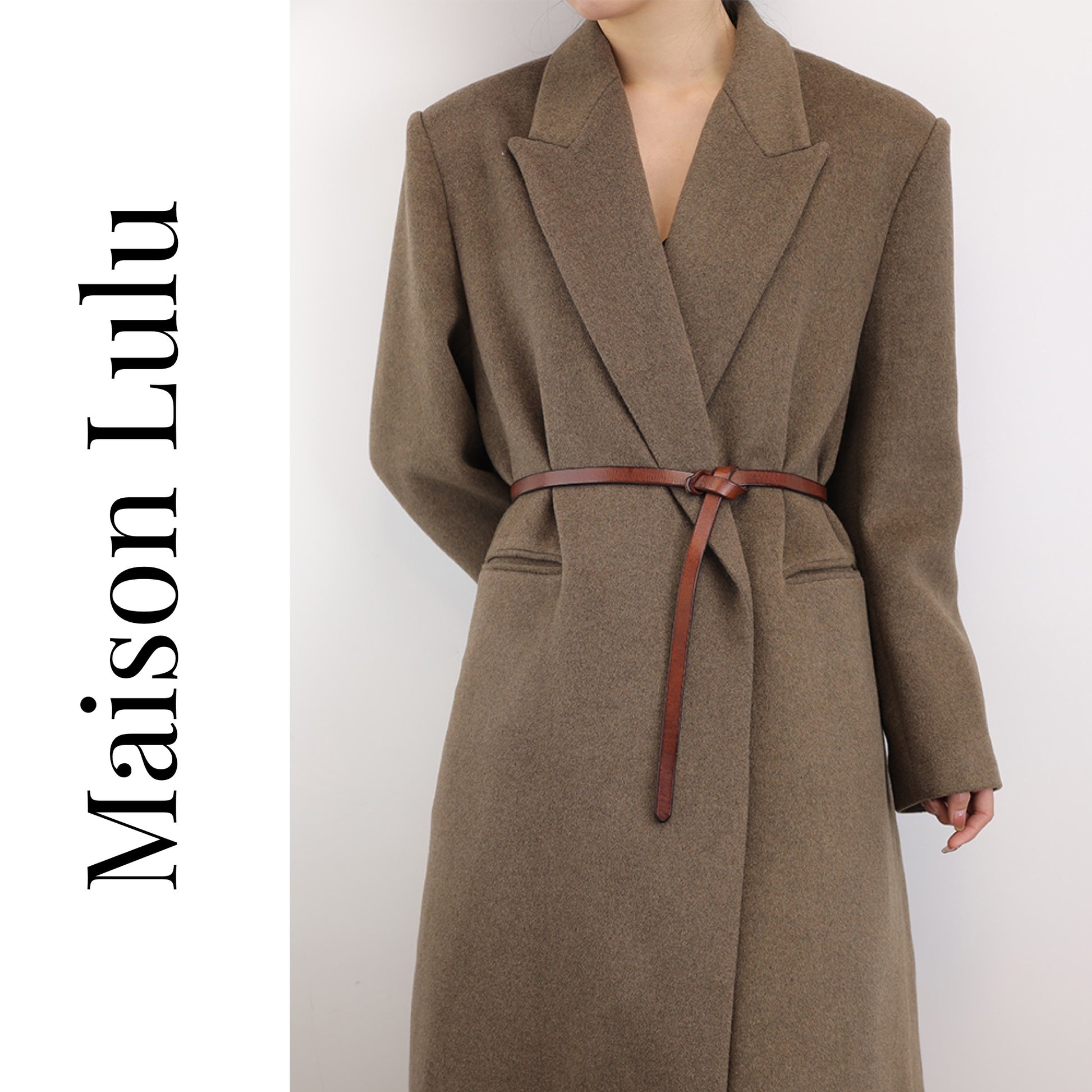 A woman wearing a brown coat with a brown leather knot belt tied around the waist.