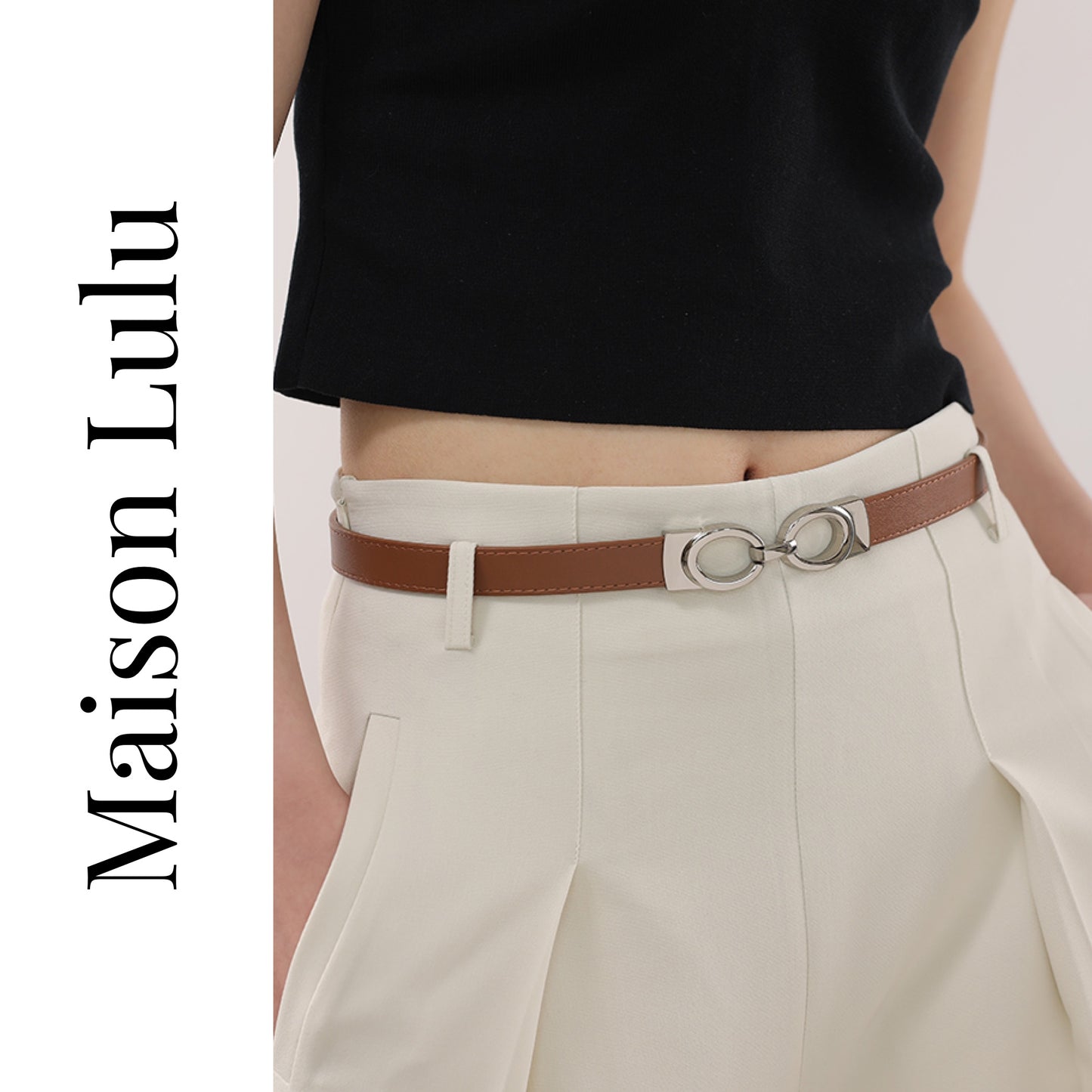 Person wearing a black top and beige pants with a brown belt, featuring the brand 'Maison Lulu'.