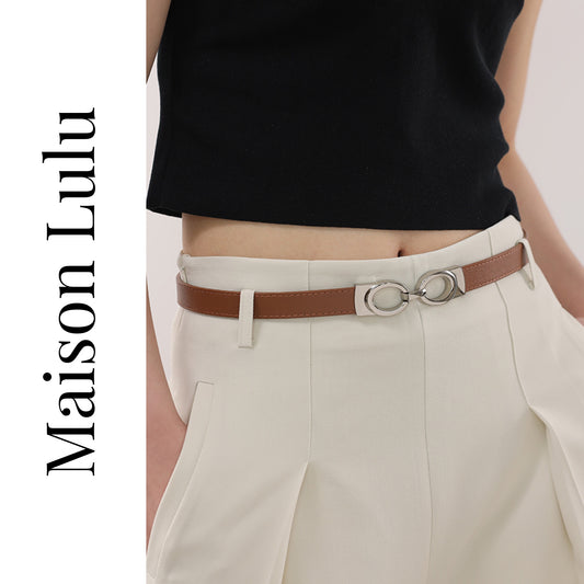 Person wearing a black top and beige pants with a brown belt, featuring the brand 'Maison Lulu'.