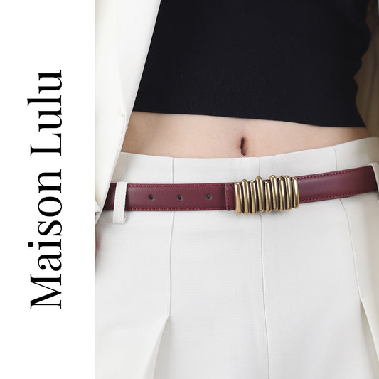 Person wearing a burgundy belt with a gold buckle, white pants, and black top, with 'Maison Lulu' branding.