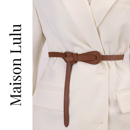 Brown belt worn around a white coat with 'Maison Lulu' branding.