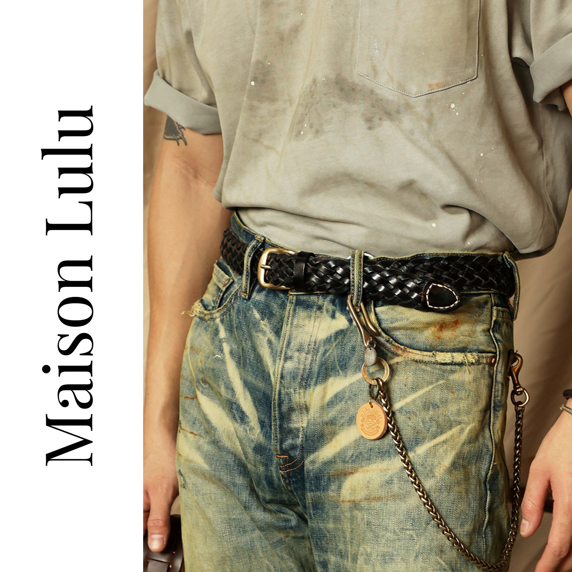Person wearing a belt with a chain detail, featuring the brand 'Maison Lulu'.