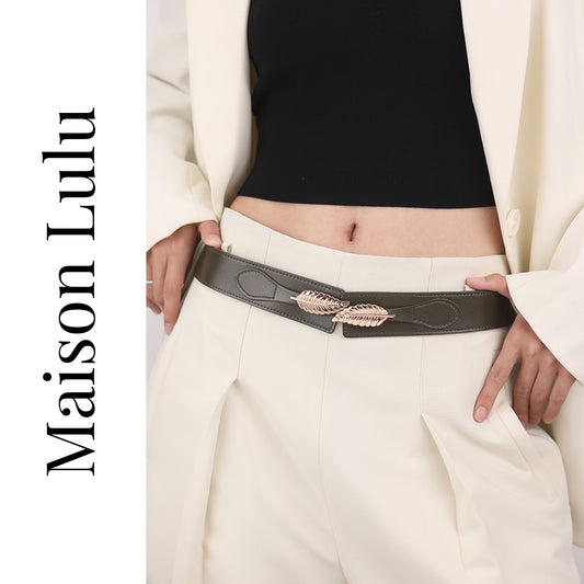 Person wearing a belt with a feather design, standing against a white background, featuring the brand 'Maison Lulu'.