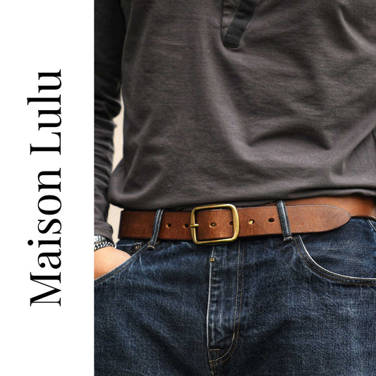 Person wearing a brown belt with a gold buckle, paired with a gray shirt and blue jeans, on a white background with 'Maison Lulu' branding.