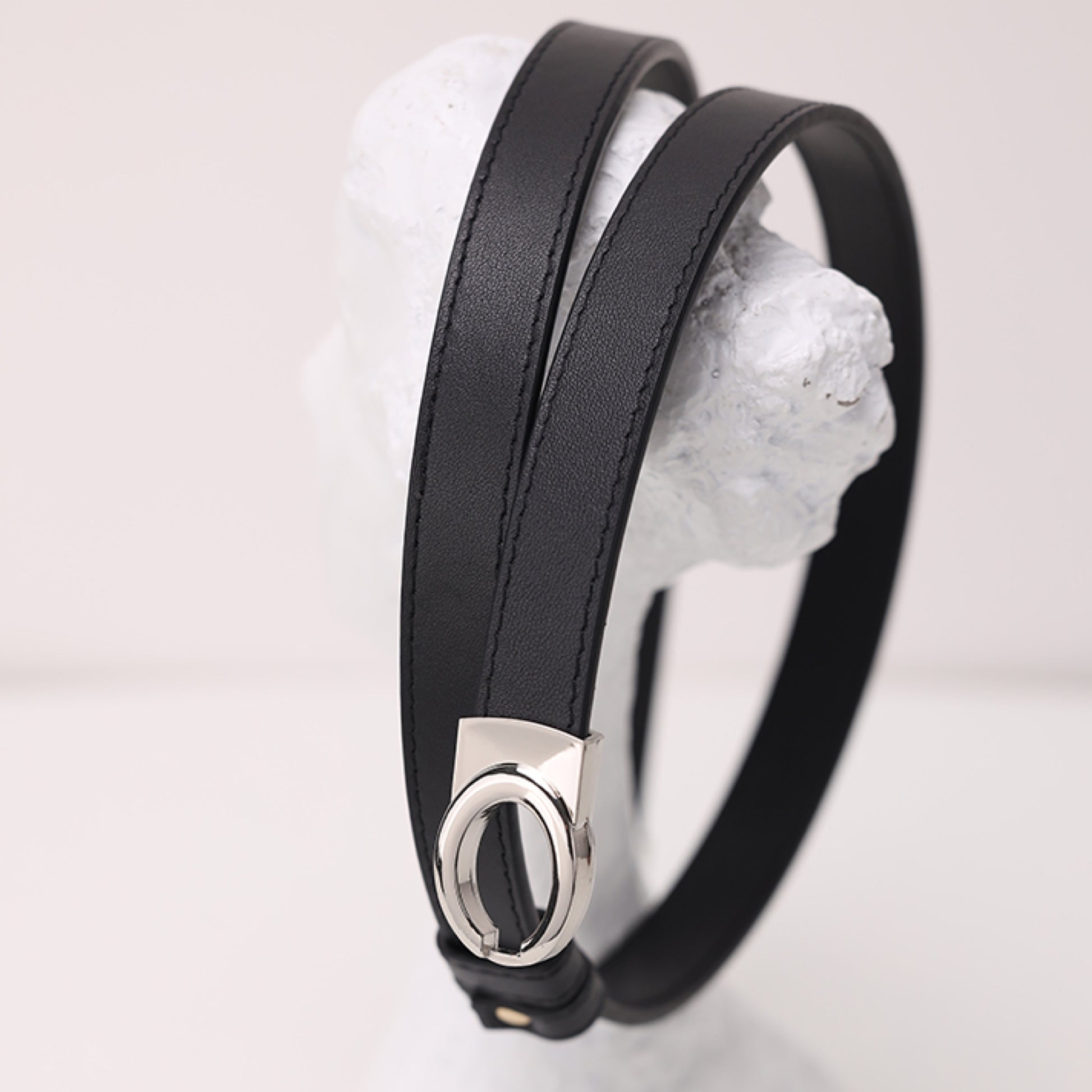 Black leather bracelet with a silver clasp on a white background