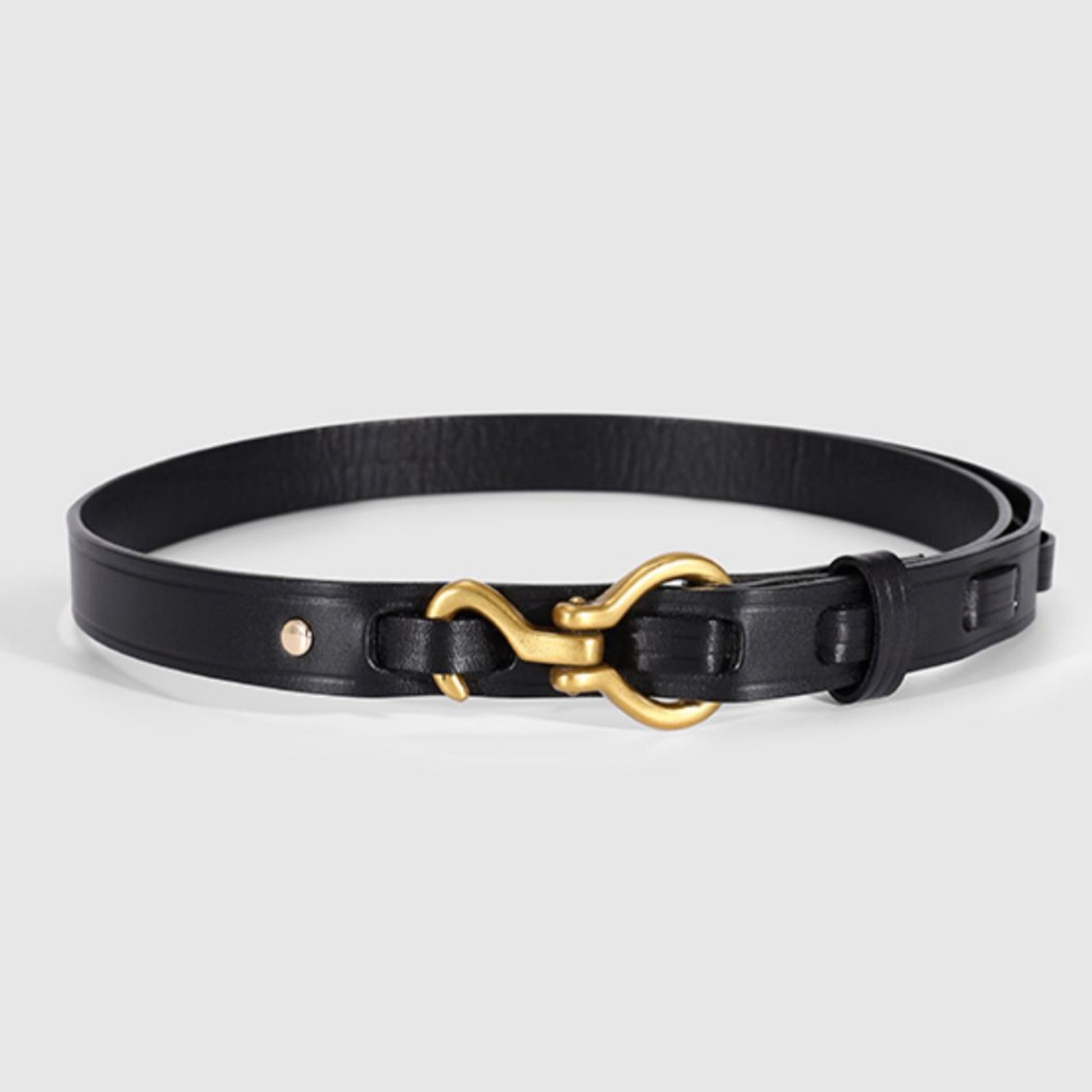 Black leather belt with a gold buckle on a light gray background