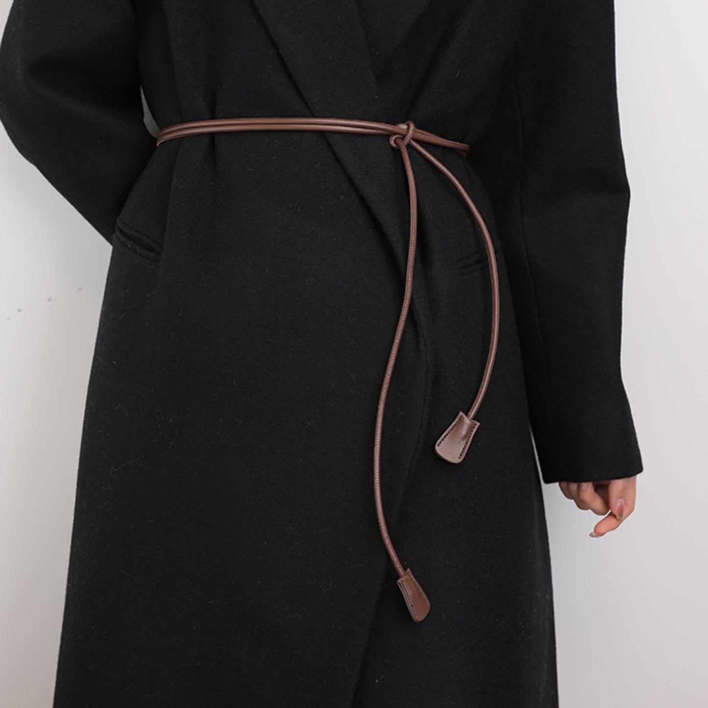 Black coat with a brown belt on a white background