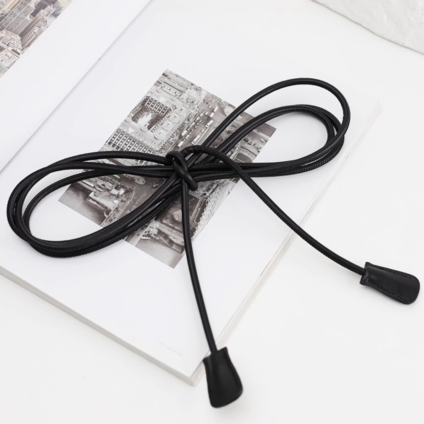 Black cable with a plug on a white surface