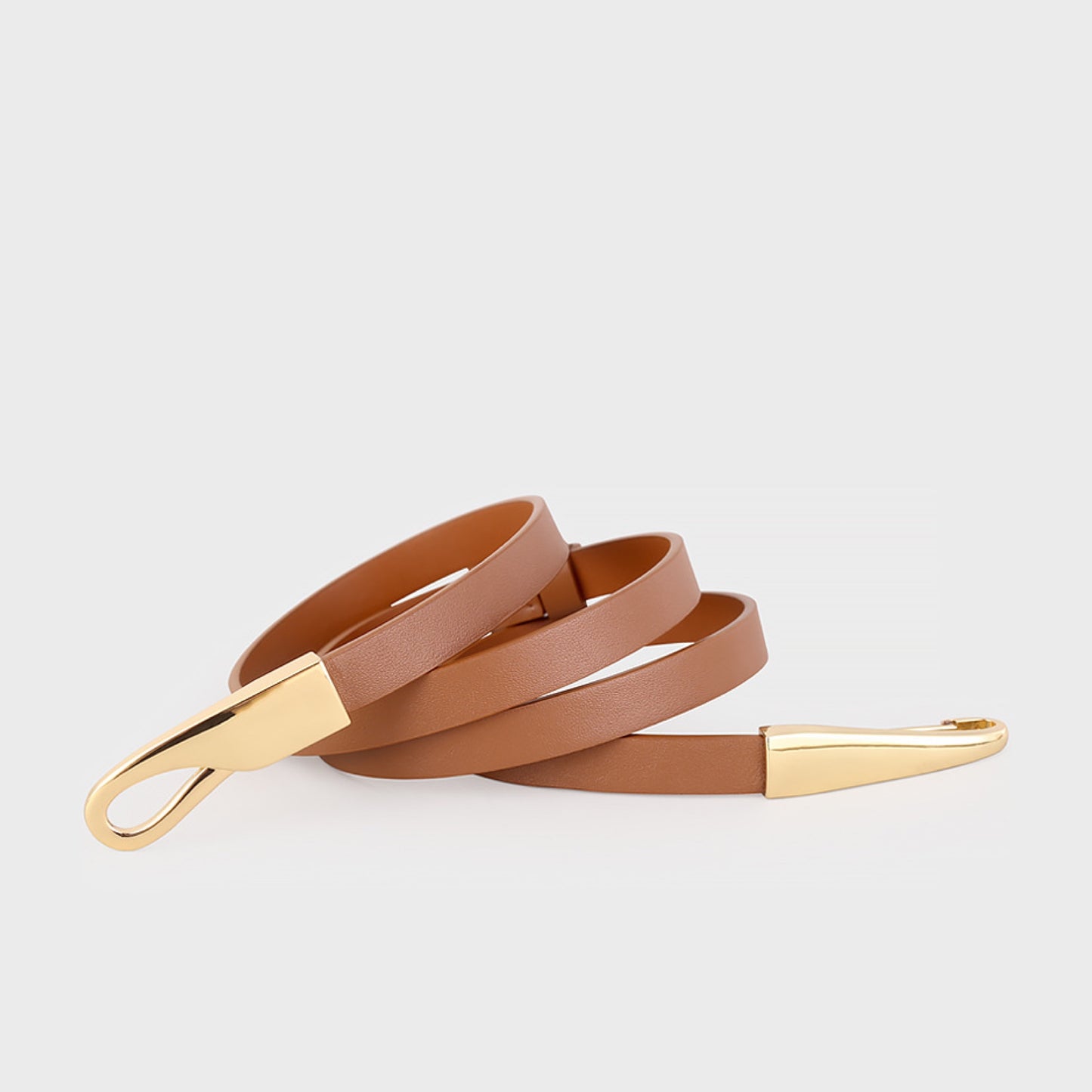 Brown leather belt with gold hardware on a light gray background