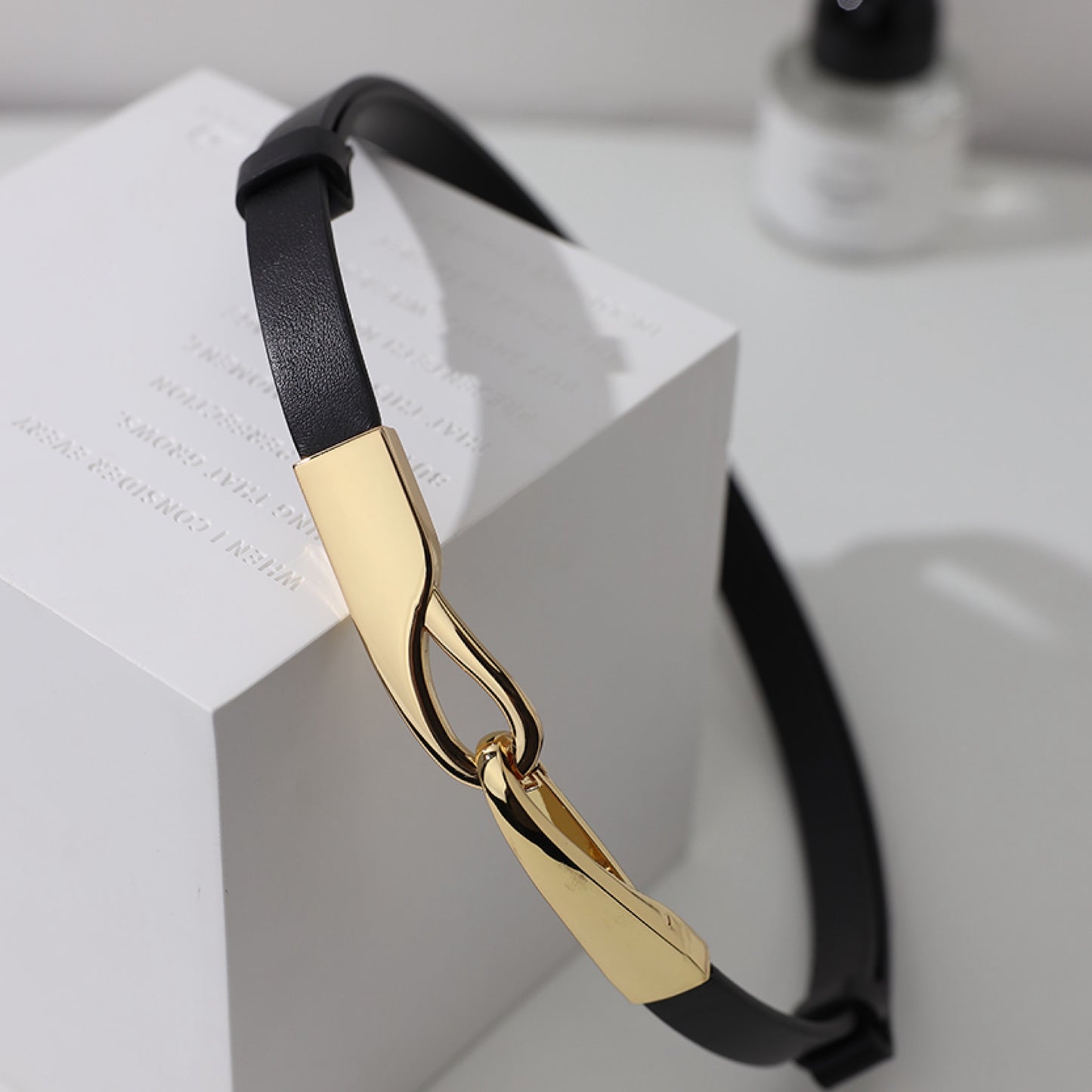 Gold and black headband on a white surface
