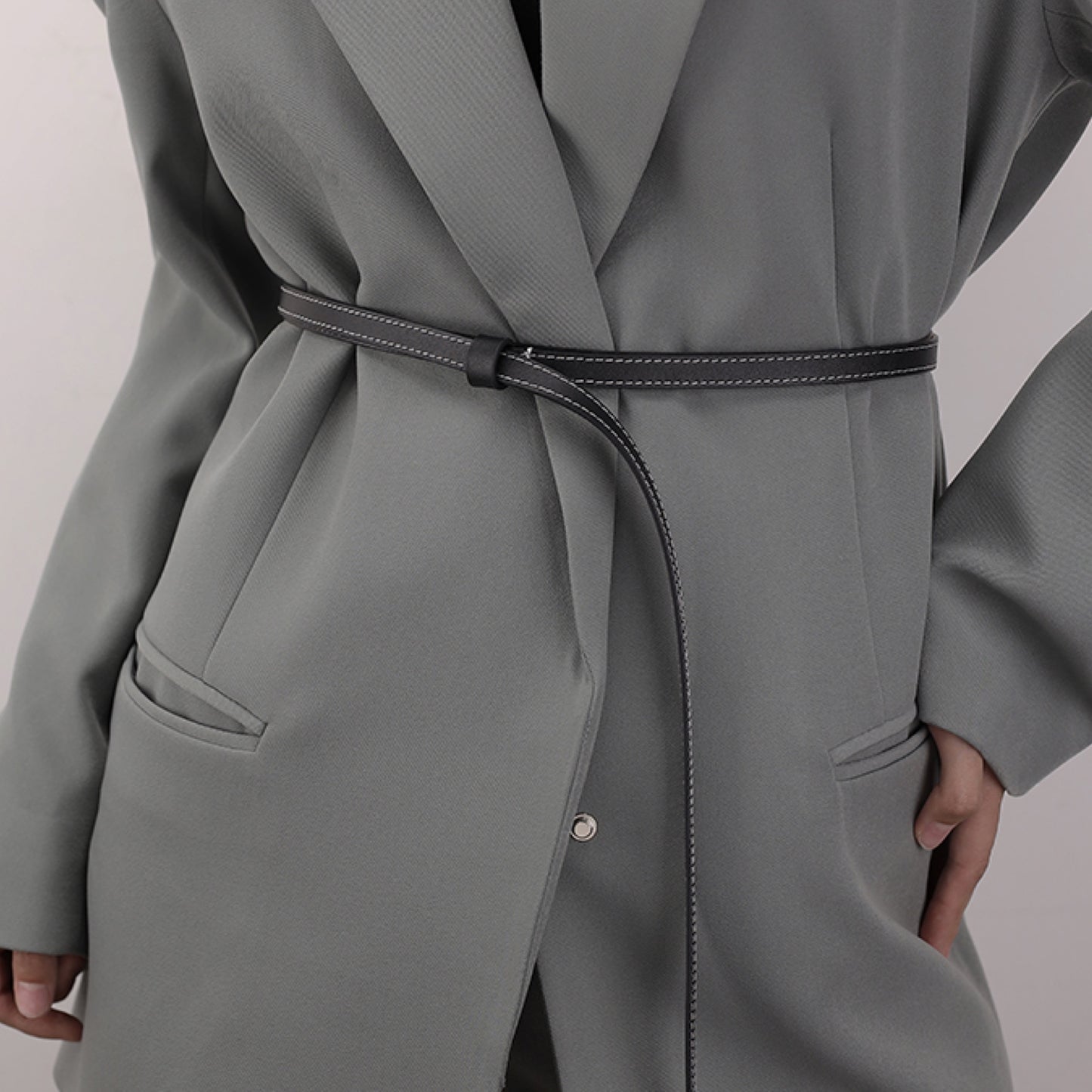 Gray coat with a belt on a plain background