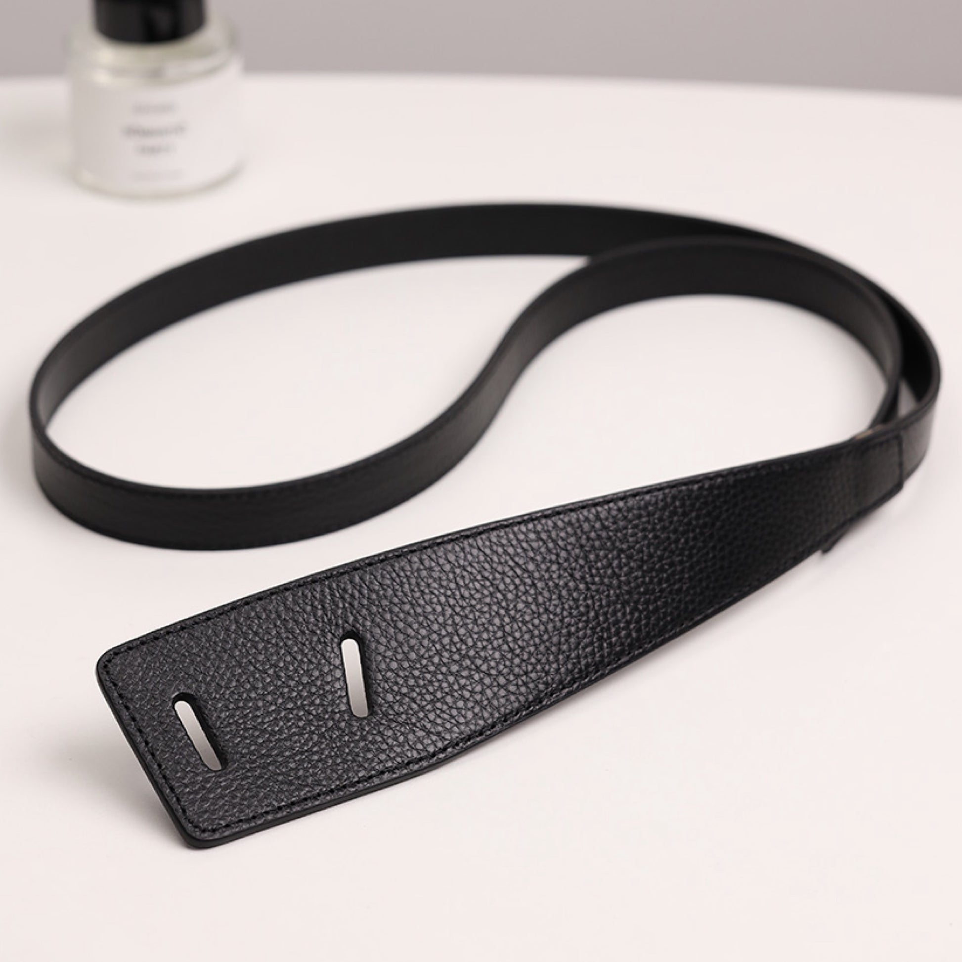 Black leather belt on a light gray background
