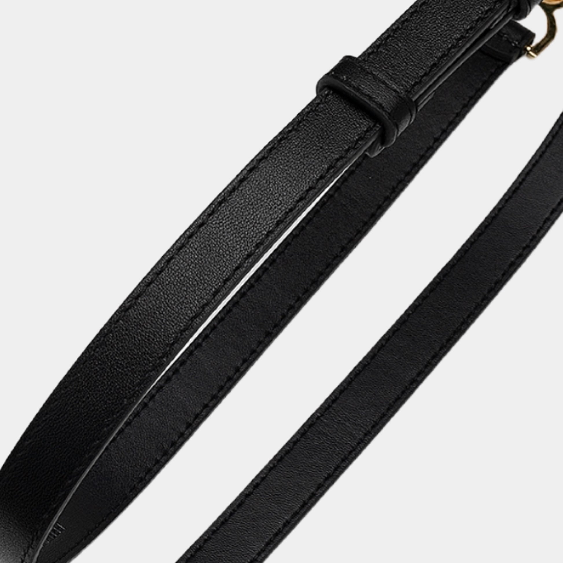 Close-up of a black leather belt on a light gray background