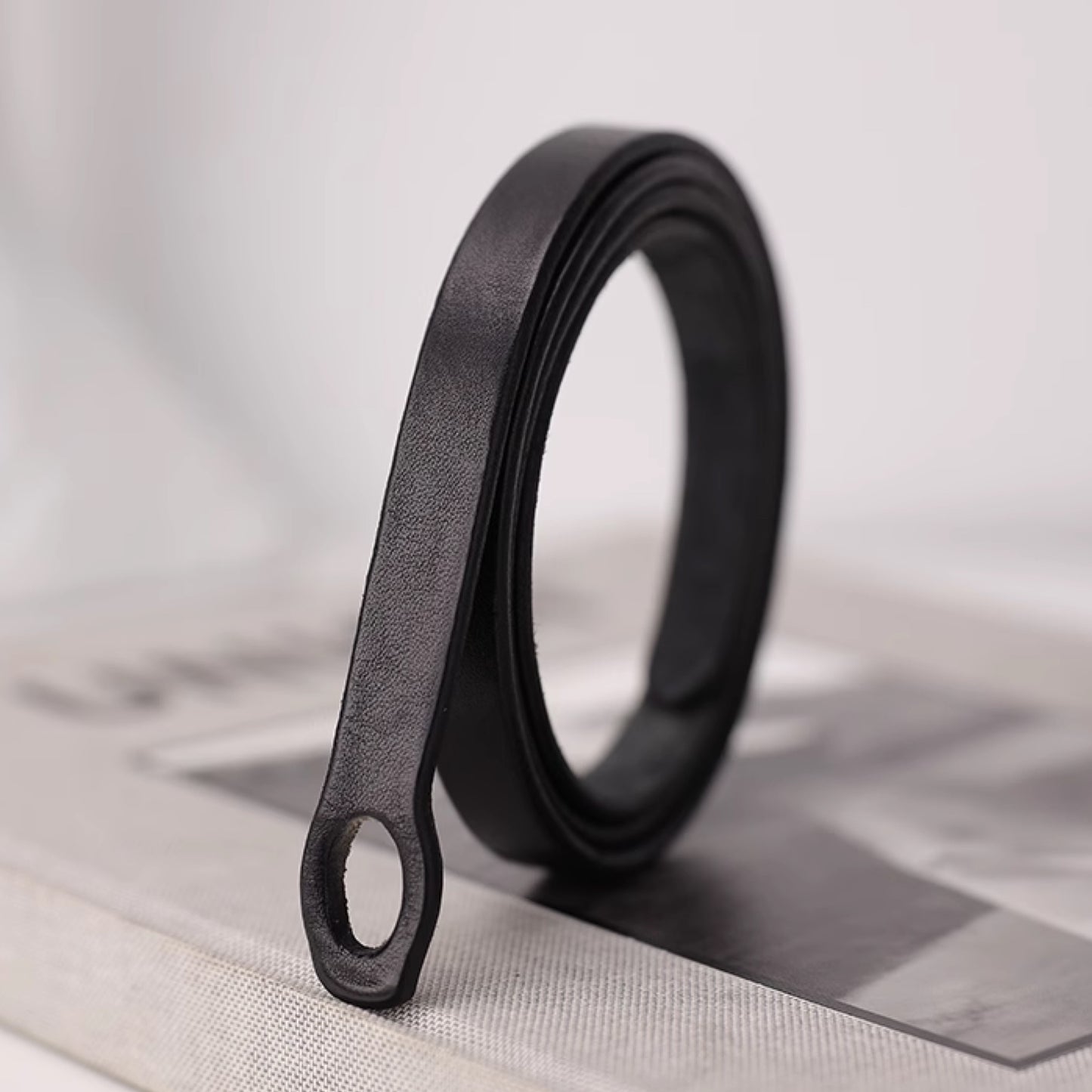Black metal belt buckle on a light gray surface