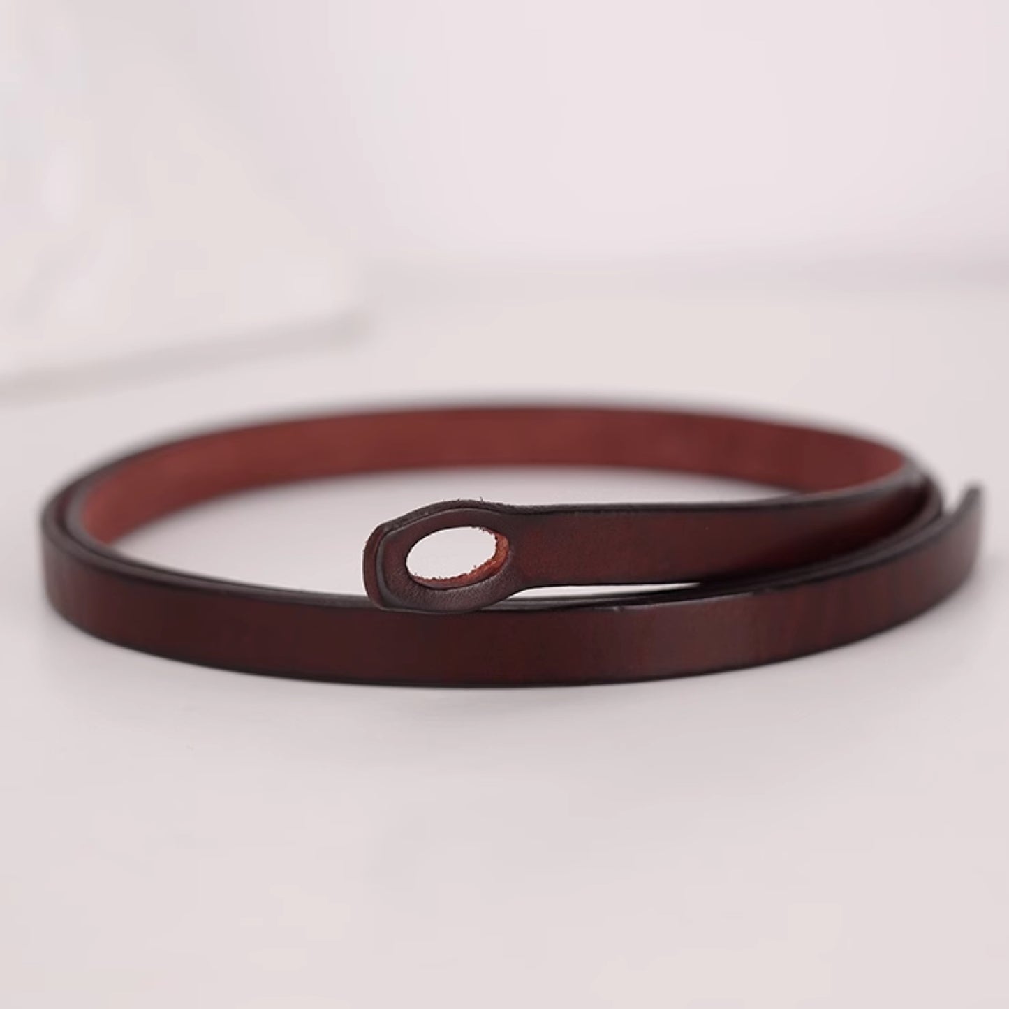 Brown leather belt on a light gray background