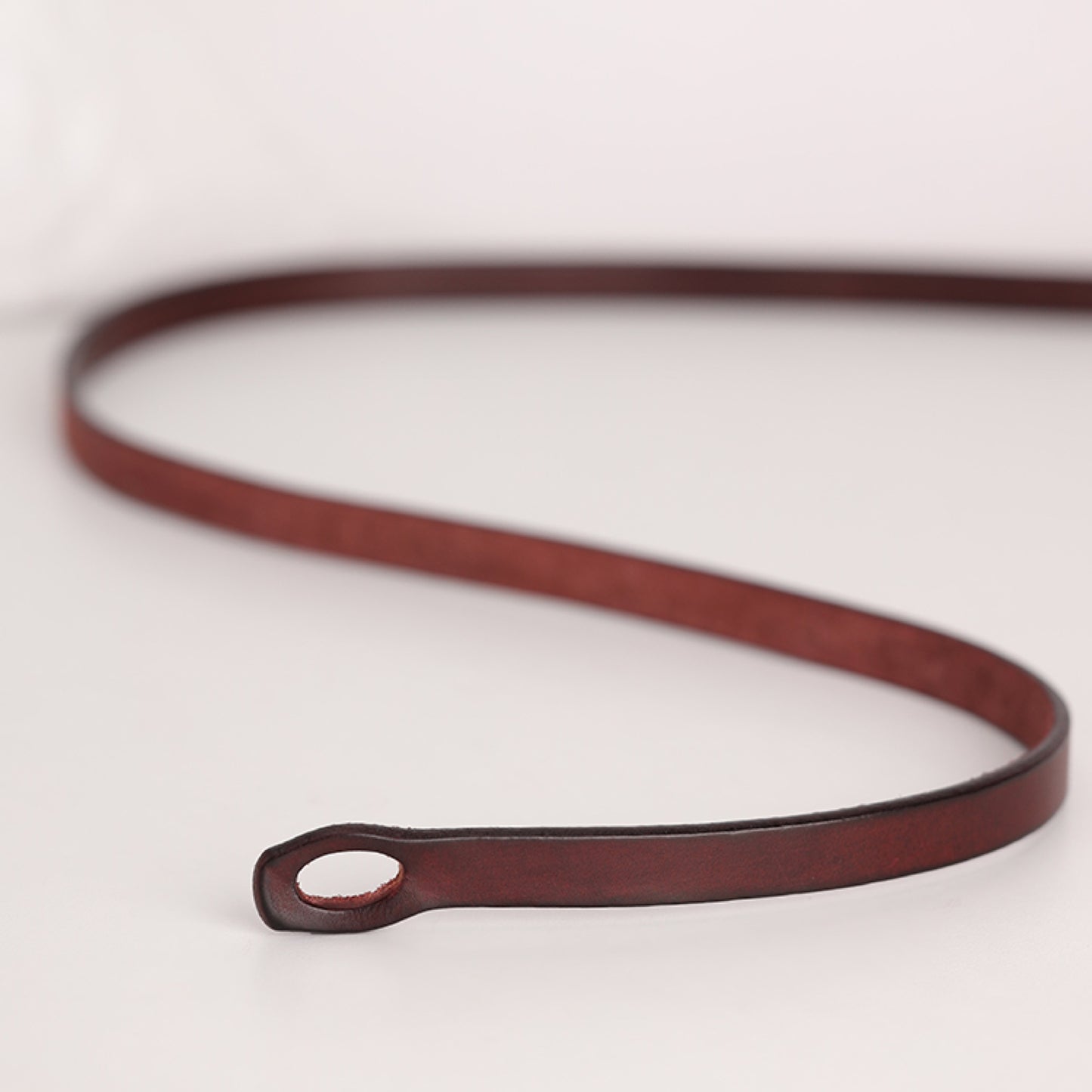 Brown leather belt on a light gray background