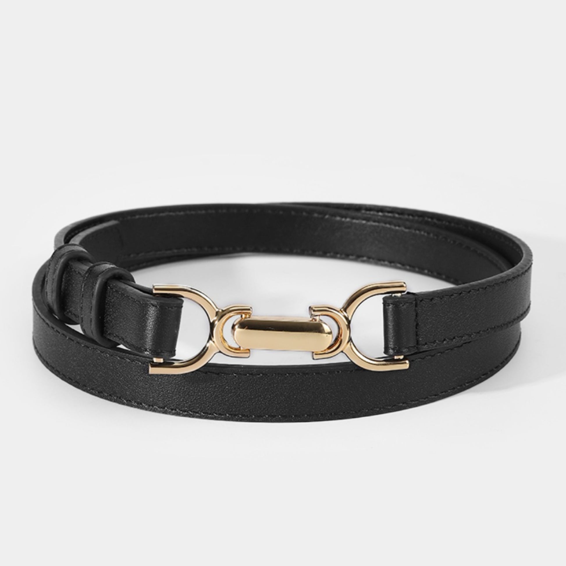 Black leather belt with gold hardware on a white background